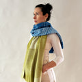 woman wearing shawl blue and moss green on white background