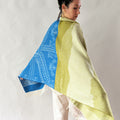 woman wearing shawl blue and moss green on white background